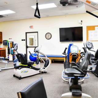 A fitness center with various exercise machines and equipment arranged in a spacious indoor setting.
