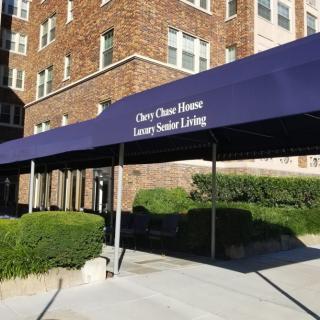 Entrance to a senior living facility with a blue awning.