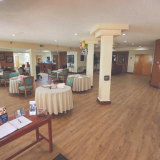 A spacious lobby with tables and columns, featuring a welcoming reception area.