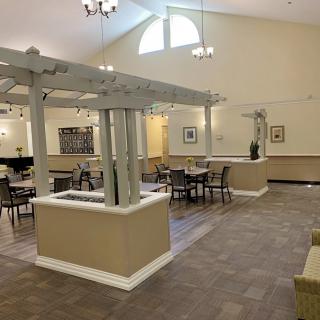 A spacious dining area with tables and chairs, featuring elegant decor and lighting.