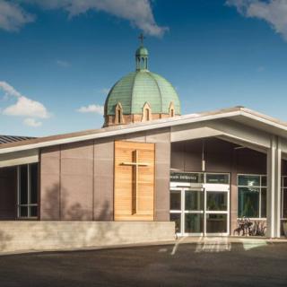 A modern church building with a prominent dome and cross.