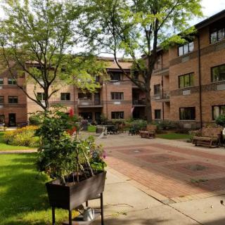 A peaceful courtyard in a residential apartment complex with trees and potted plants.