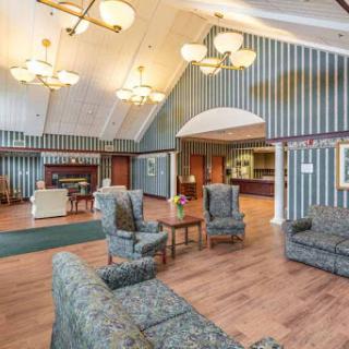 A spacious and elegantly designed lobby featuring comfortable seating, stylish chandeliers, and decorative striped walls.
