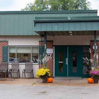 A welcoming entrance adorned with autumn flowers and decorative pumpkins.