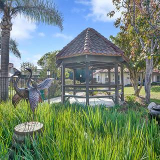 A charming gazebo surrounded by lush greenery and a serene outdoor setting.