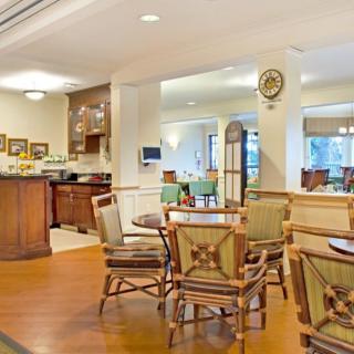 An inviting dining area with wooden tables and chairs, featuring a warm and elegant interior design.