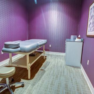 A peaceful massage room with a treatment table and soft lighting.