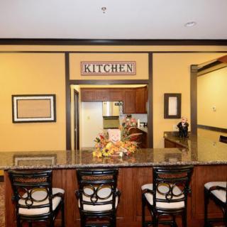 A kitchen view with a counter and four chairs in a cozy home setting.