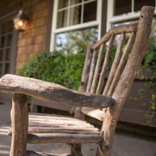 A rustic wooden chair sits on a porch, adding a natural touch to the outdoor setting.