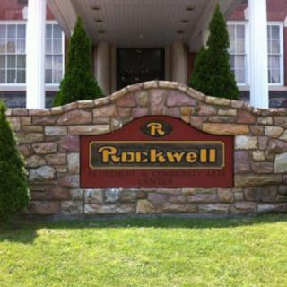 A stone sign for 'Rockwell' marks the entrance of a building.