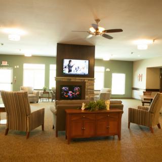 A modern living room with comfortable seating and a television mounted on a central wall.