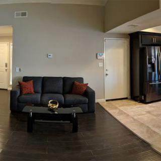 A modern living room with a sofa, coffee table, and open kitchen area.