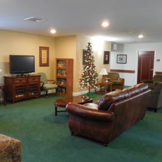 A cozy living room with a television, leather sofa, and decorative elements.