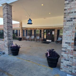 A welcoming entrance featuring brick columns, potted plants, and decorative lighting.