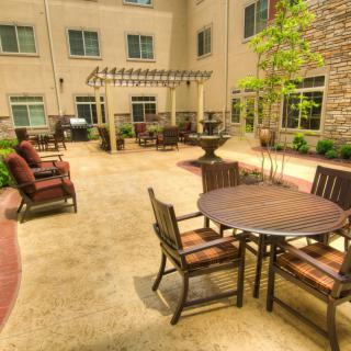 A sunny courtyard featuring outdoor seating with tables and chairs, ideal for relaxation.