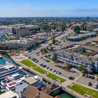 Aerial view of a coastal town with a marina and various buildings.