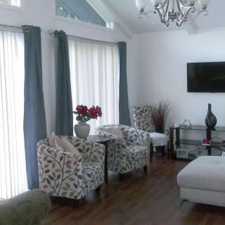 A modern living room with floral chairs and a chandelier.