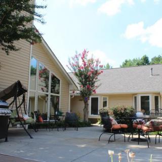 A cozy backyard with a patio, outdoor furniture, and swing beside a house.