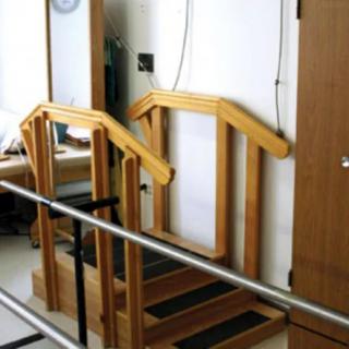 Indoor physical therapy staircase with handrails for rehabilitation exercises.