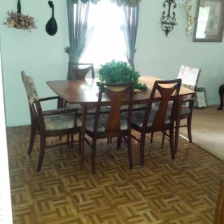 A cozy dining room with a wooden table and six chairs.