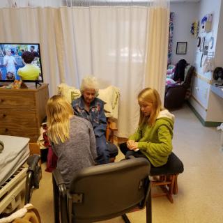 Family members spending quality time with an elderly woman in a care home.