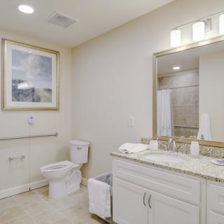 A modern and clean bathroom interior featuring a sink, mirror, and toilet.