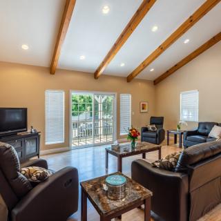 A modern living room with wood beams, sofas, and a television.