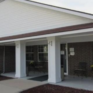 Front view of a house with a covered porch and pillars.
