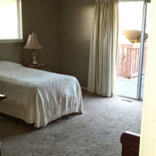 A simple bedroom with a single bed and access to a balcony.