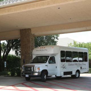 A shuttle bus parked under a covered entrance.
