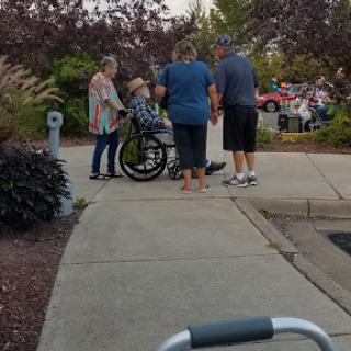 A group of people assisting someone in a wheelchair outdoors.