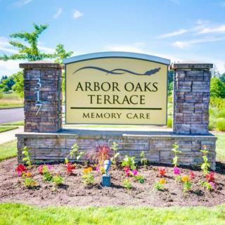 Entrance sign for Arbor Oaks Terrace Memory Care, surrounded by landscaped flowers.