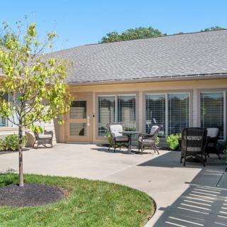 A cozy outdoor patio area with seating and landscaped surroundings.