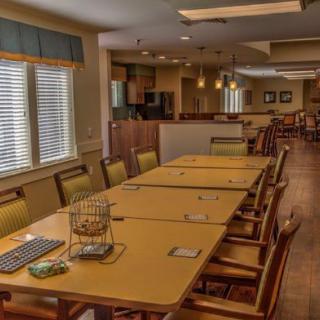 A cozy dining area with a long table and chairs, adjacent to a kitchen space.
