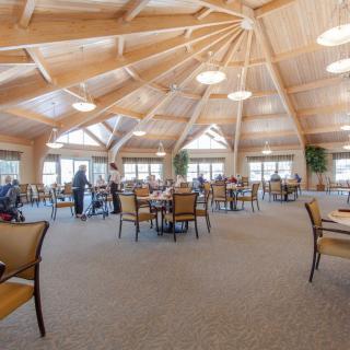 A spacious dining area with a wooden ceiling and natural lighting.