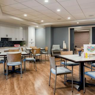 A modern indoor dining area with chairs and tables on a wooden floor.