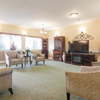 A spacious living room with comfortable seating, a large television, and traditional decor.