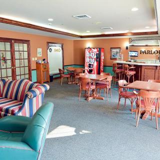 A comfortable lounge with various seating options, tables, and a vending machine.