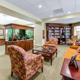 A cozy living room with an aquarium, bookshelves, and comfortable seating.
