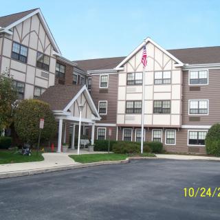 A residential building with a driveway and an American flag.