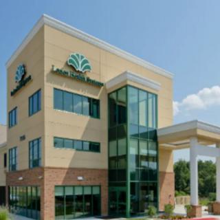 A modern healthcare building with a glass entrance and brick accents.