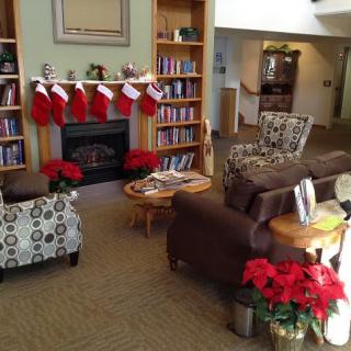 A cozy living room decorated for the holidays with stockings hung on the fireplace and poinsettias adding a festive touch.