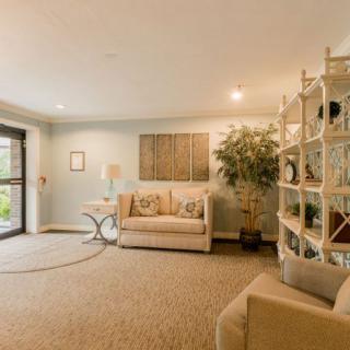 A cozy and modern living room featuring a comfortable sofa, stylish shelving unit, and decorative wall art.