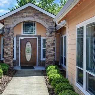 A well-maintained house exterior with a stone facade and an inviting front entrance.