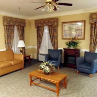 A cozy living room with a sofa, two chairs, and a coffee table.