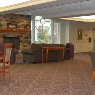 A cozy lounge area with sofas, a fireplace, and large windows.