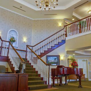 Elegant lobby with a grand staircase and piano.