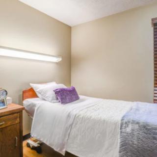 A minimalist bedroom with a single bed and a nightstand.