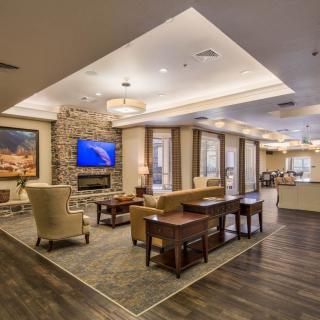 A modern lobby with comfortable seating, a fireplace, and a television.