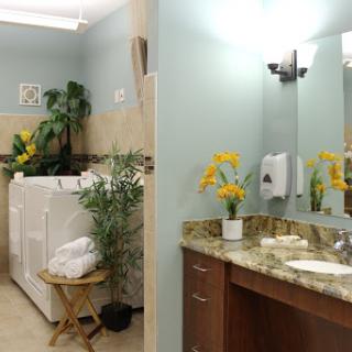 A stylish laundry and bathroom area featuring modern appliances and decorative plants.